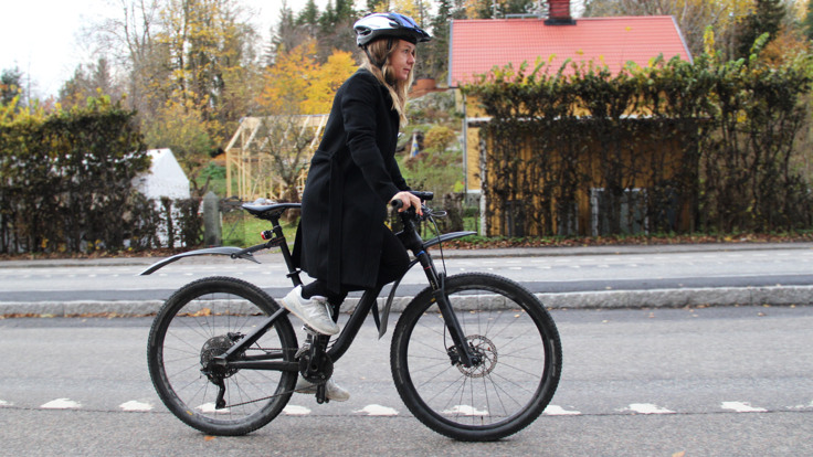 Kvinna cyklar på gata.
