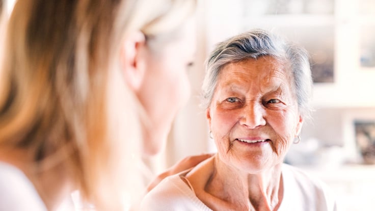 En yngre kvinna tittar på en äldre kvinna som ler