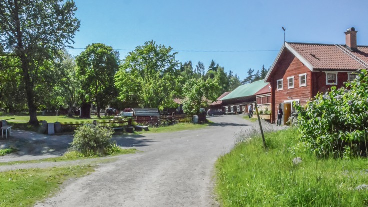 Gårdsplan, gräs, röda uthus
