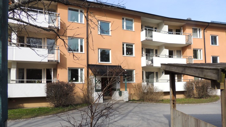 Trevåningshus med en asfalterad gård