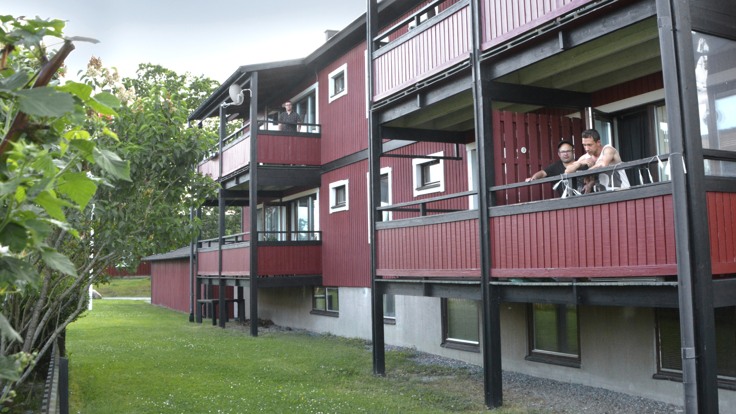 Rött tvåvåningshus med balkonger