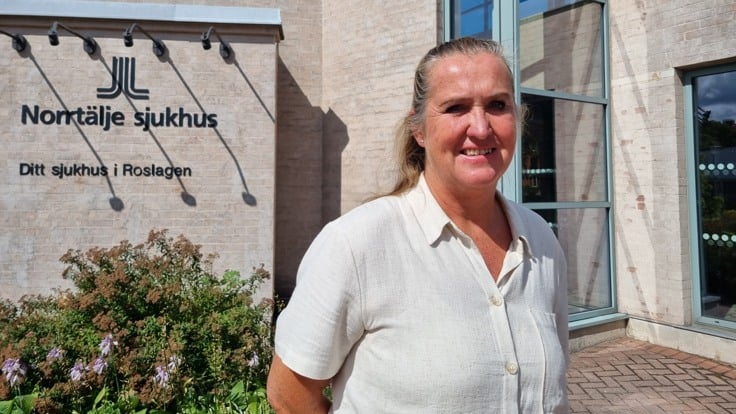 Kvinna framför hus med texten Norrtälje sjukhus