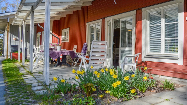 Altan framför rött hus med vita knutar