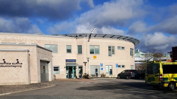 Rakennuksen eteen pysäköity keltainen kuorma-auto.