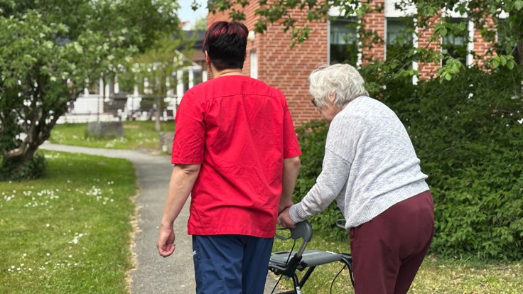 En man och en kvinna går på cykel på en trottoar.