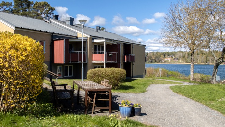 Trädgårdsmöbler och hus på en sjötomt