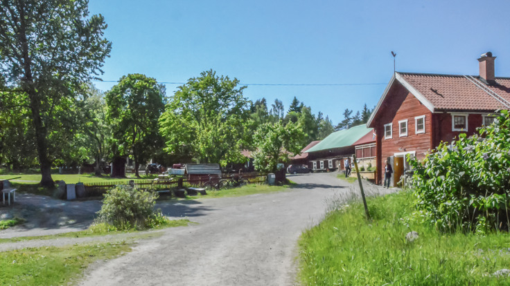 Gårdsplan, gräs, röda uthus