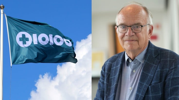 En man som står bredvid en flagga.