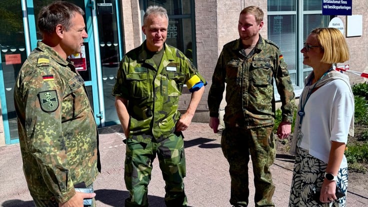 En grupp män och kvinnor som står framför en byggnad.