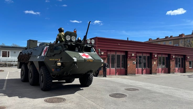 Ett militärfordon parkerat framför en byggnad.