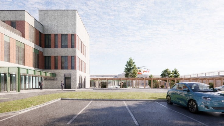 En blå bil parkerad på en parkeringsplats bredvid en byggnad.