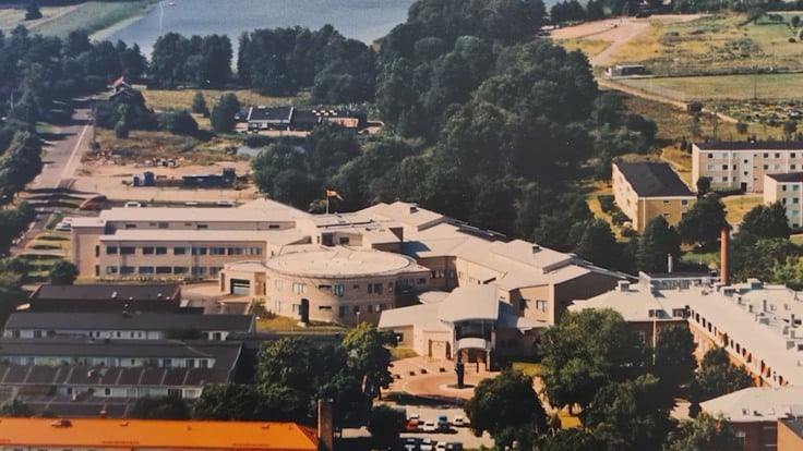 En flygbild av en stad med en sjö i bakgrunden.