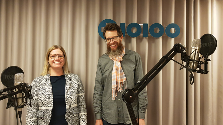 Kvinna och man står och ler i studiomiljö. Mickar i förgrunden.