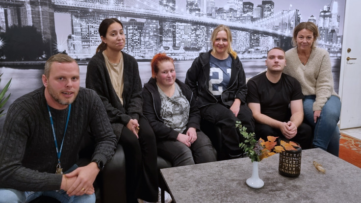 Sex personer sitter i en soffa.