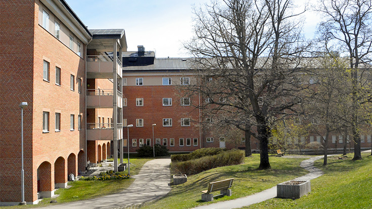 Stort rött tegelhus vid grön park