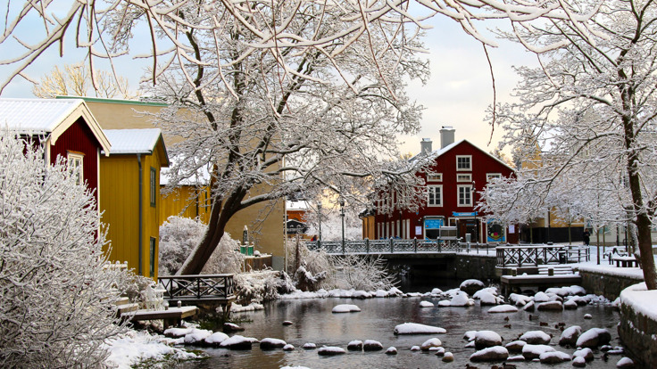 Norrtäljeån med hus i bakgrunden. Snö på marken.
