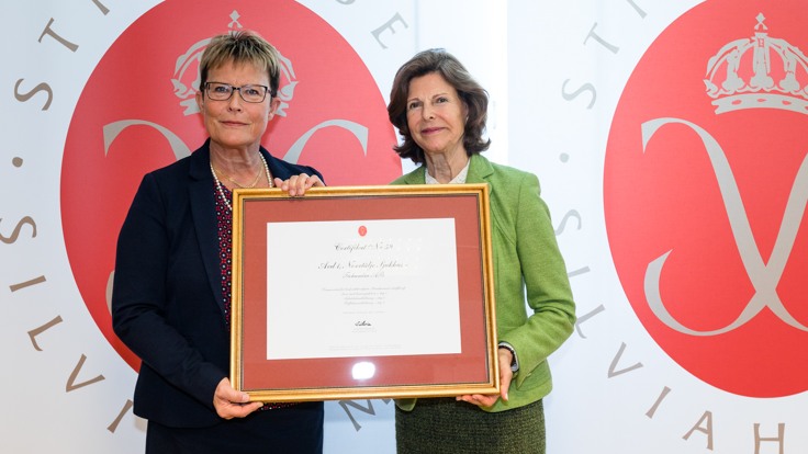 Margareta Söderman och Drottning Silvia håller tillsammans i ett inramat diplom.