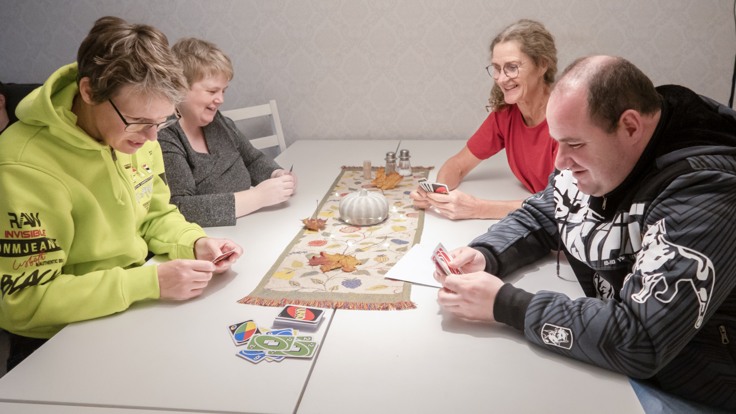 Fyra personer runt ett bord som spelar kort