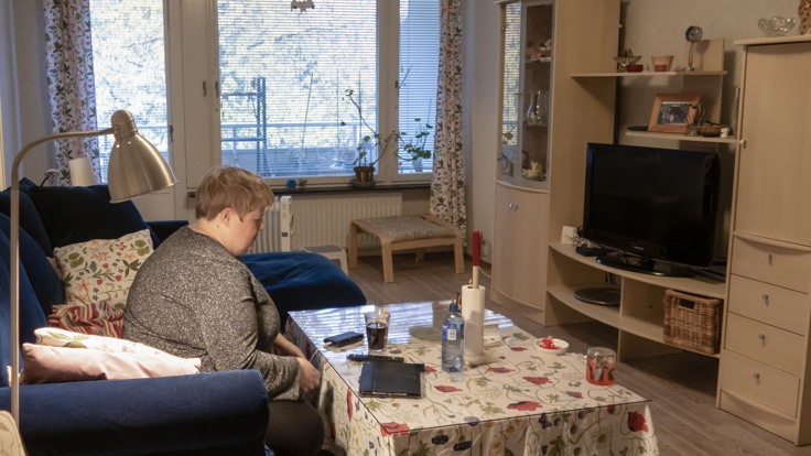 Kvinna som sitter i en soffa i ett vardagsrum