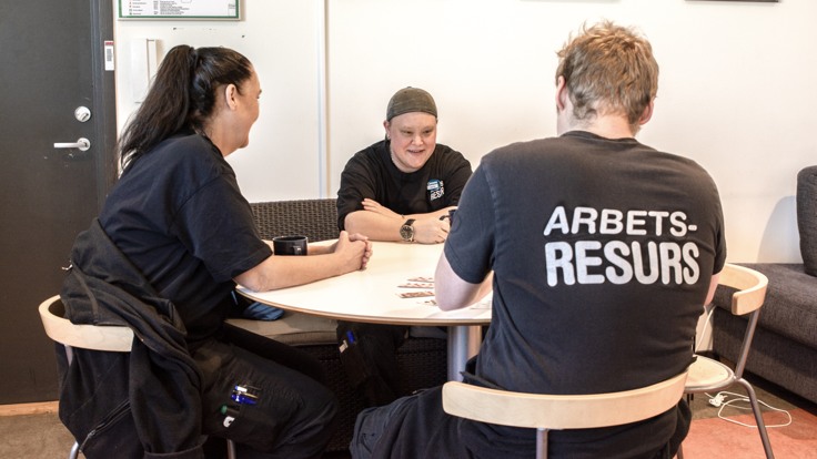 Tre personer runt bord i fikarum