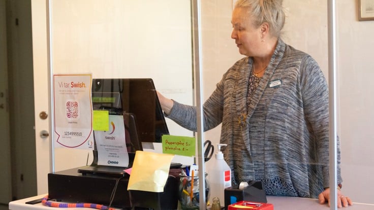 Kvinna som står vid en kassaapparat