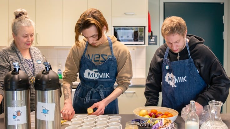 Tre personer som står och jobbar i ett cafékök