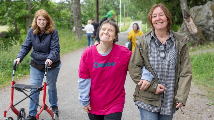 Deltagare och personal som går längst en grusväg