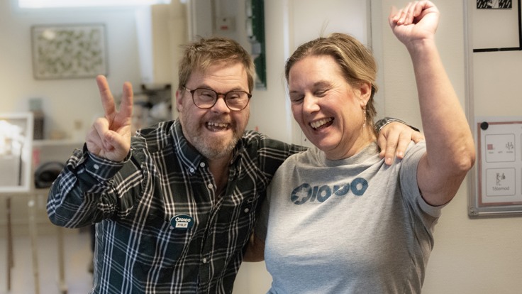 Deltagare och personal som gör V-tecknet och dansar