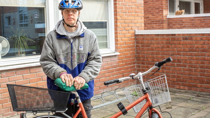 Man som står vid en cykel
