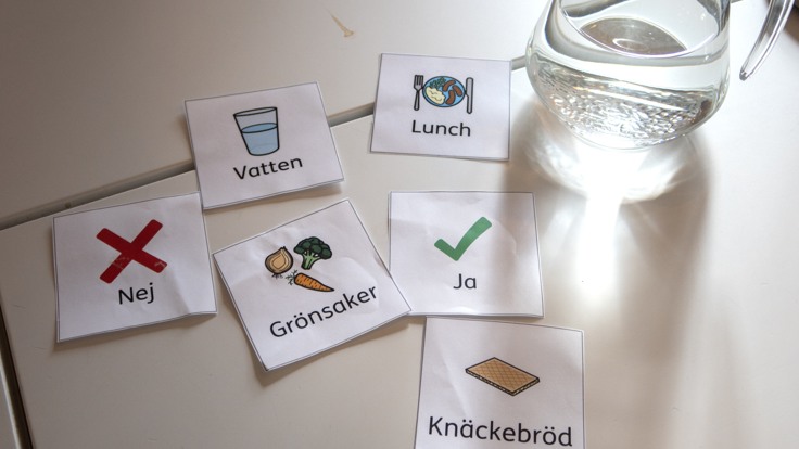 Bildstödskort och vattenkaraff på ett bord