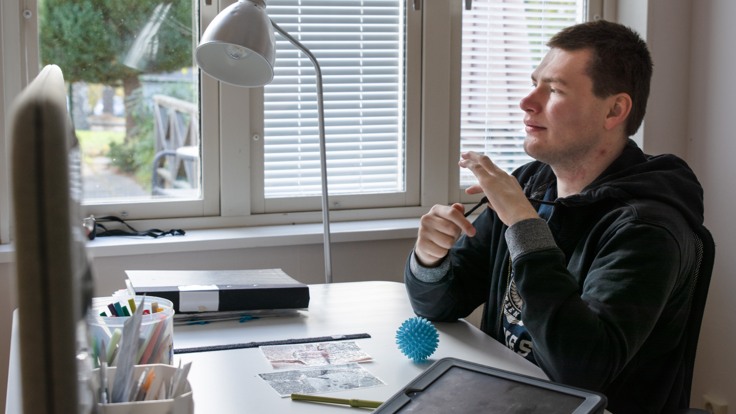 Kille/deltagare sitter vid ett skrivbord
