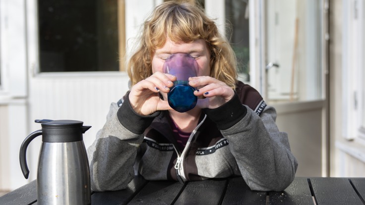Deltagare som sitter på en altan och dricker kaffe