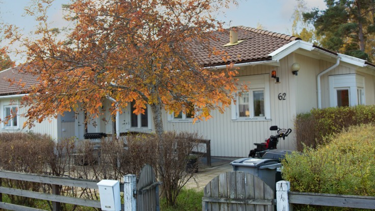 Vitt trähus bakom träd i höstfärger