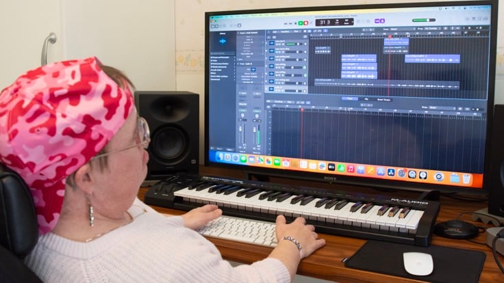 Deltagare sitter vid en dator med ett musikredigeringsprogram