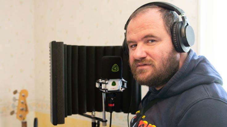 Man med hörlurar vid en mikrofon